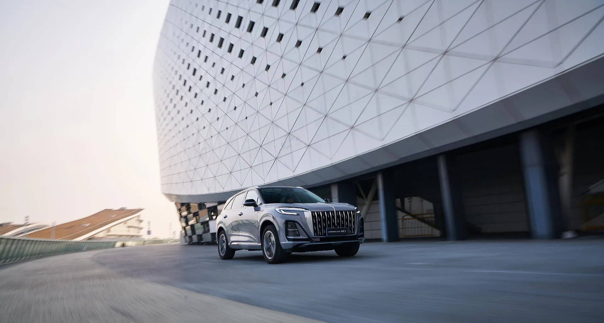 Сребрист Hongqi HS3 пред стадион